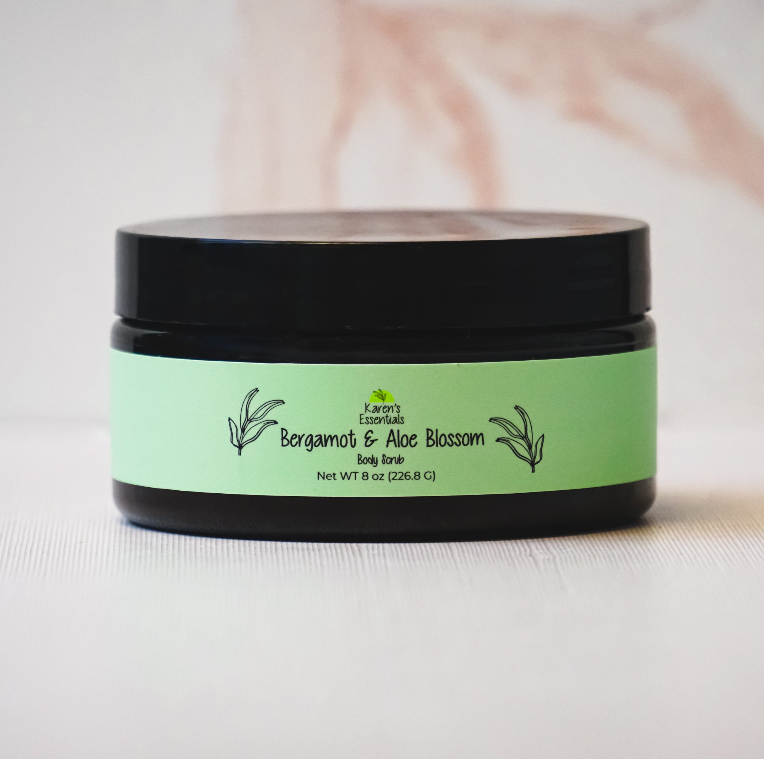 picture of a black jar with a green label on it, with the words Karen Essentials which is the company name. With the words Bergamot and Aloe Blossom Body Scrub Net WT 8 oz